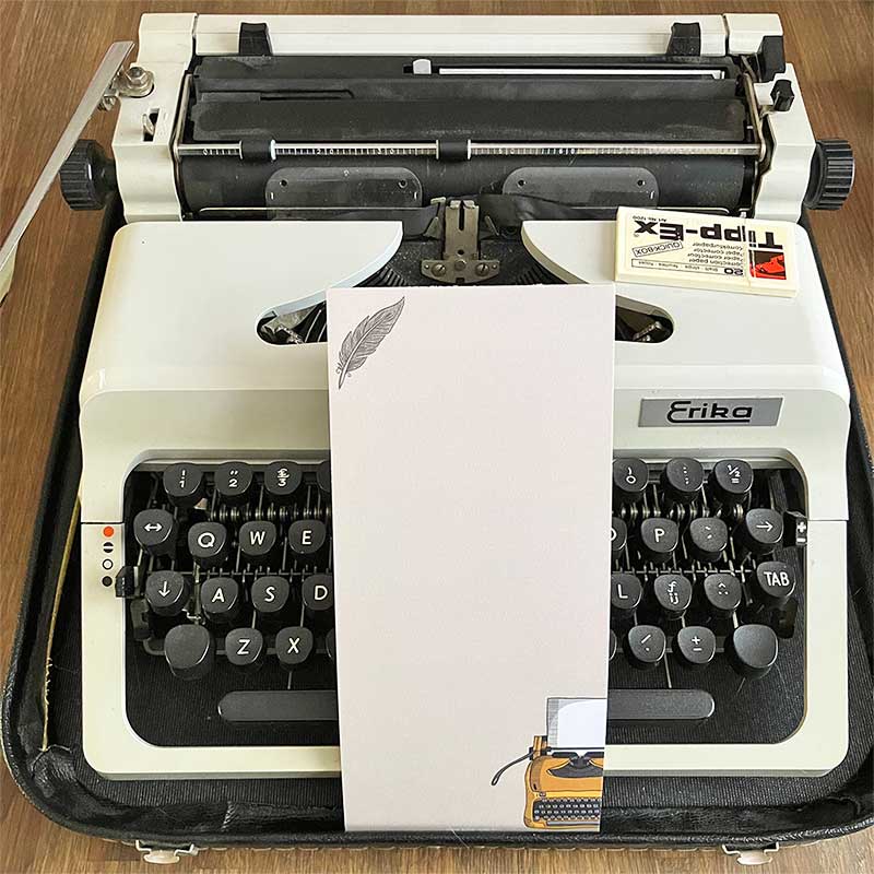 Licht gelinieerd beige notitieblok met typemachine en veer bij typemachine