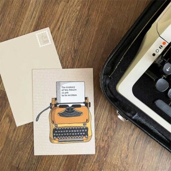 Beige postkaart met okergele typemachine en tekst 'the history of the future is yet to be written' op het papier