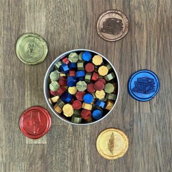 Wax in de kleuren rood, geel, blauw en groen in blikje en lakzegels ernaast